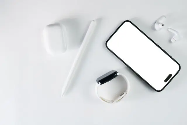 Top view of smartphone and tech accessories, emphasizing minimalist design and wireless connection.